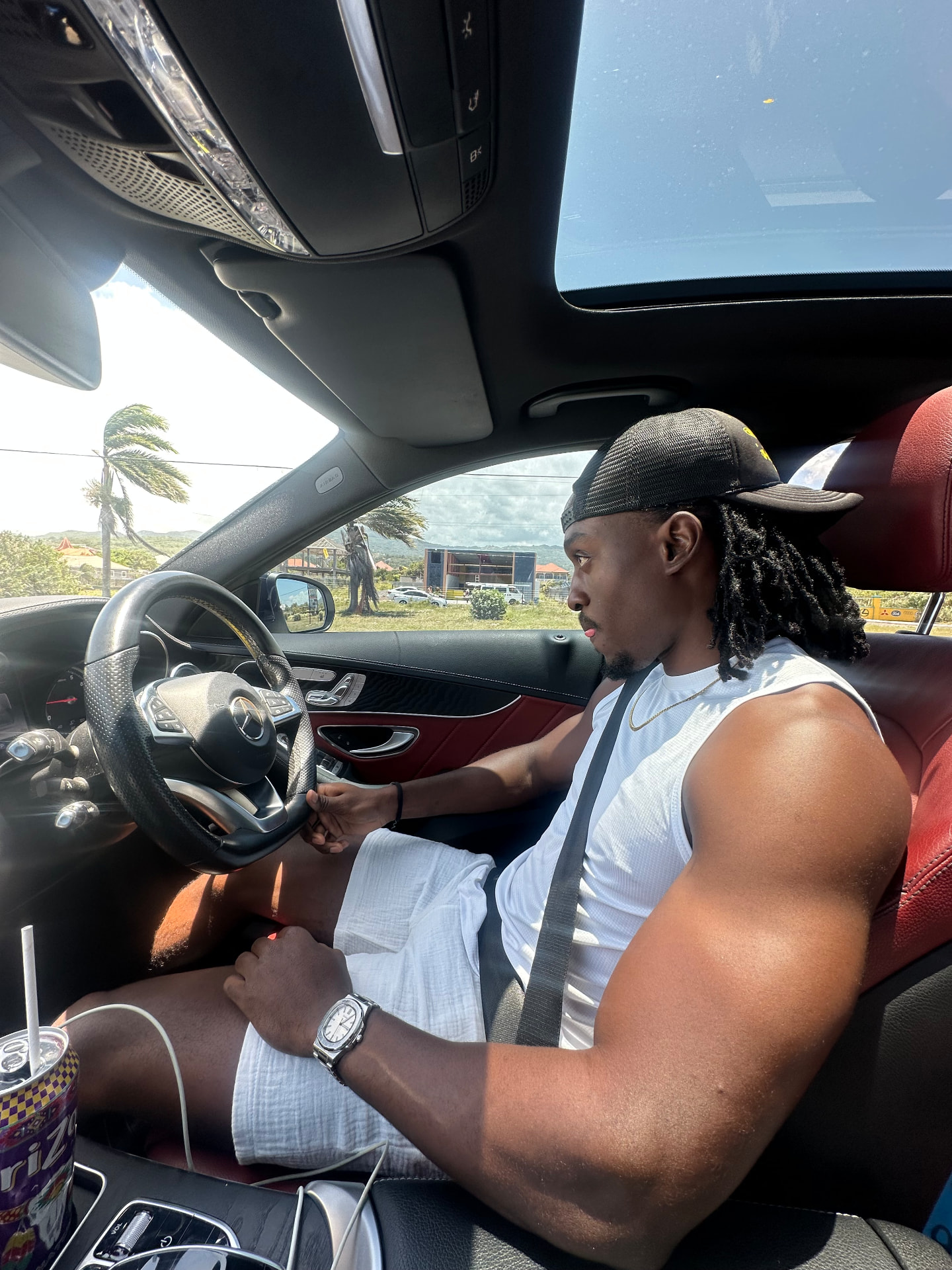 Musa X seated behind the wheel of his car
